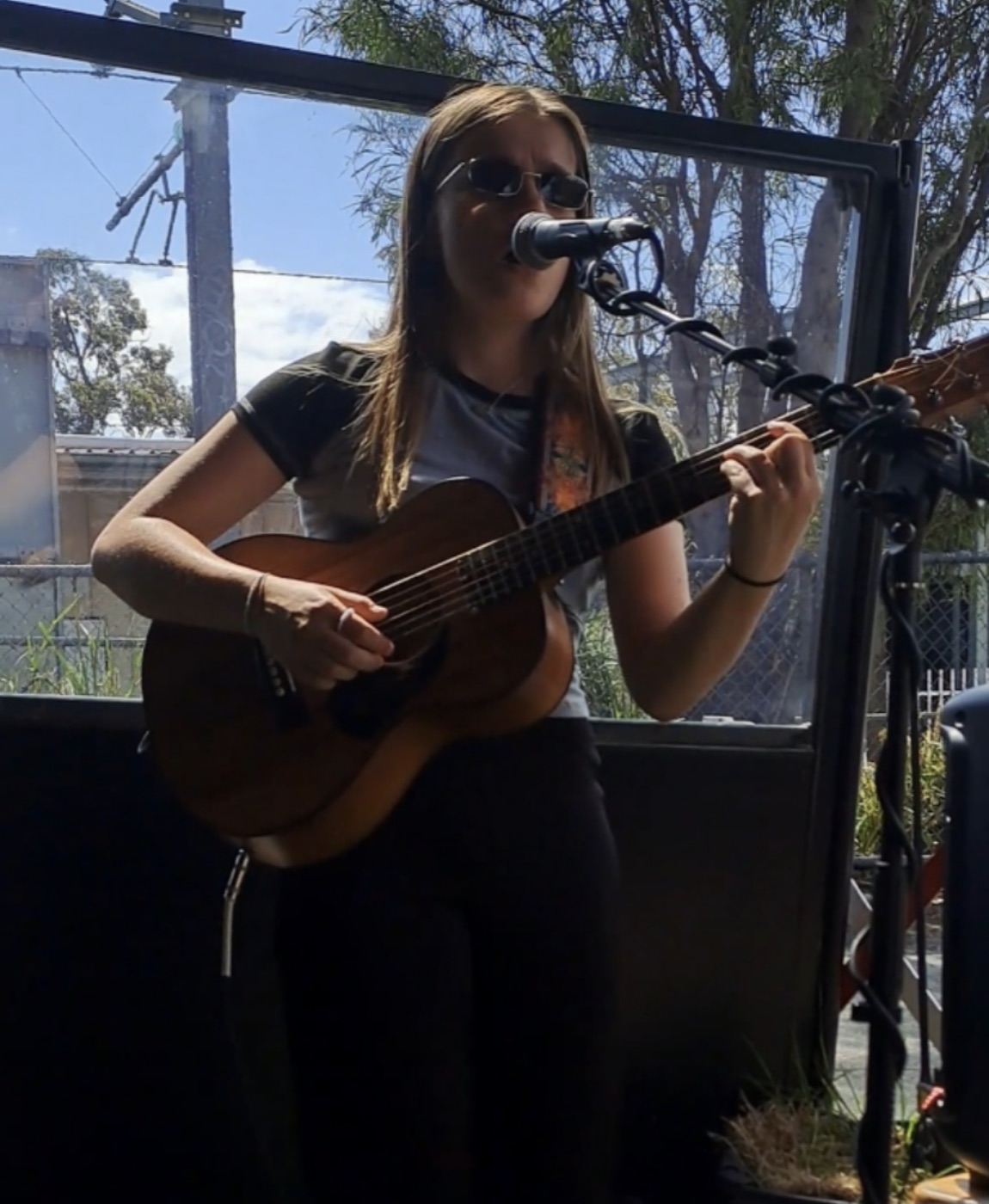 Ella Gray performing live at a sunny outdoor venue